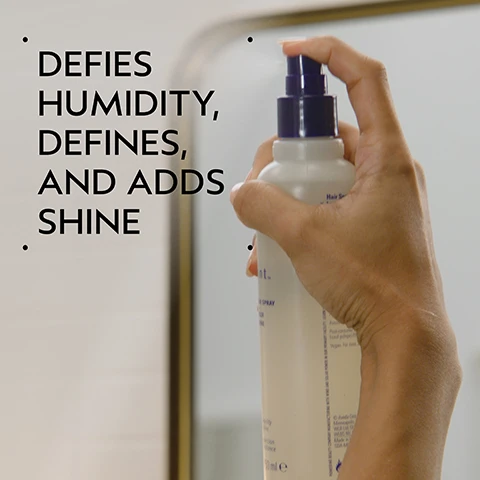 Image 2 - A hand holds a white spray bottle with a purple pump, spraying a fine mist, with overlaying text that reads DEFIES HUMIDITY, DEFINES, AND ADDS SHINE. Image 3 - A dark green image with a central white circle containing pink rose petals, a white jasmine flower, and dried cloves. Text reads: BLISSFUL PURE-FUME AROMA AN AROMATIC BLEND WITH JASMINE, ROSE, CERTIFIED ORGANIC CLOVE AND OTHER PURE FLOWER AND PLANT ESSENCES. Image 4 - A split image shows a woman with dark, voluminous, curly hair on the left and the same woman with sleek, straight dark hair on the right, with visible text reading BEFORE, AFTER, Unwashed Hair, Results with Brilliant Shampoo, Conditioner, Damage Control Retexturing Gel, Anti-Humectant Pomade and Medium Hold Hair Spray and Smooth Infusion™ Perfectly Sleek Styling Crème. Blow dried with brush. Image 5 - A guide showing four steps for hair care: first, hands cleansing hair with lather, with text 01 CLEANSE Brilliant™ Shampoo; second, hands squeezing conditioner from a tube into a palm, with text 02 CONDITION Brilliant™ Conditioner; third, a person spraying product onto wet curly hair, with text 03 PREP Brilliant™ Damage Control; and fourth, a collection of Aveda hair products on a shelf, with text 04 STYLE Brilliant™ Anti-Humectant Pomade and Medium Hold Hair Spray and Smooth Infusion™ Perfectly Sleek. Image 6 - A split image shows a woman with curly dark hair; the left panel, labeled BEFORE Unwashed Hair, displays frizzy, less defined hair, while the right panel, labeled AFTER, shows her hair with smooth, defined curls, accompanied by the text Results with Brilliant Shampoo, Conditioner, Damage Control, Retexturing Gel, Humectant Pomade, Hair Spray, and Wooden Paddle Brush. Blow dried with diffuser attachment. Image 7 - A clear, circular drop of liquid with tiny air bubbles is visible on a white background. Image 8 - The image displays three white certification logos on a dark green leafy background: 100% Vegan with a V symbol, Certified B Corporation with a B in a circle symbol, and Cruelty Free International with a leaping bunny and stars symbol.