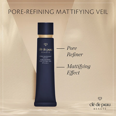Image 1 - A dark blue cosmetic tube with a gold cap, labeled clé de peau BEAUFÉ and PORE-REFINING MATTIFYING VEIL, displayed against a soft, light-colored background, with additional text stating Pore Refiner and Mattifying Effect, as well as SPF 25+PA++.
Image 2 - A woman with long brown hair, wearing a navy blue blazer, touches her cheek with one hand while showcasing a natural makeup look, with text overlay that reads Visibly reduces pores appearance & shininess to improve skin texture along with the brand logo for clé de peau BEAUTE.
Image 3 - A woman with brown hair tied back is holding a dark bottle while looking directly at the camera, wearing a navy blazer and gold hoop earrings, with text that reads In 2 weeks, pores appearance looks tightened & skin texture smoother* *98% of 102 women agreed after self-assessment.