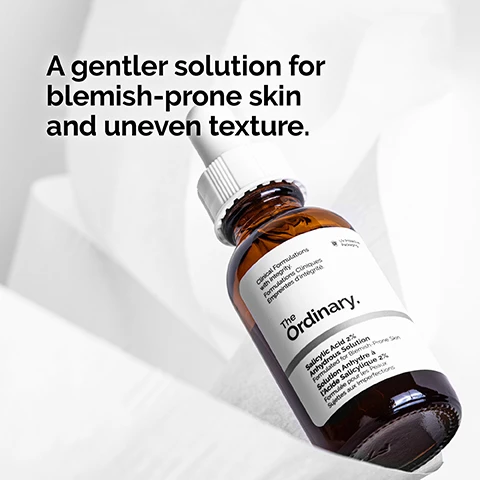 Image 1 - A brown glass bottle of The Ordinary Salicylic Acid 2% Solution is shown on a light background with the text A gentler solution for blemish-prone skin and uneven texture.
Image 2 - An image featuring clear liquid with bubbles, accompanied by the text 2% salicylic acid targets textural irregularities while removing dead skin cells.
Image 3 - A close-up of a woman applying a skincare product to her face with a focused expression, alongside the text that reads Apply daily in the evening. Use a small amount for general use.
Image 4 - A dropper with a clear serum dripping from it above a circular, translucent serum texture, with the text Anhydrous serum texture. visible beneath the image.
Image 5 - Image shows a series of skincare products organized into three categories: PREP with cleansers and toners, TREAT with water-based serums, eye serums, anhydrous solutions, and oils, and SEAL with suspensions, moisturizers, and SPF.