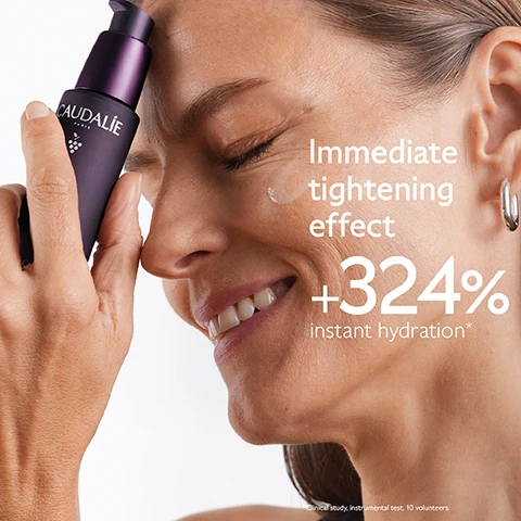 Image 1 - A woman is smiling while applying a skincare product to her face, with visible text stating Immediate tightening effect +324% instant hydration*.
Image 2 - A purple background features a bottle of Caudalie Premier Cru serum surrounded by dark grapes, with text stating Natural plumping filler improves skin volume, Longevity patent stimulates youth proteins, and Niacinamide smoothes and evens skin tone.
Image 3 - A woman is smiling while holding a bunch of dark grapes near her face, with visible text that says Targets all signs of ageing, followed by checkmarks for Wrinkles, Dark spots, and Volume.
Image 4 - Image shows three bottles of Caudalie serums on a purple background with the text Which serum suits your skin? above and labels for each serum: Premier Cru - Complete anti-ageing, Resveratrol-Lift - Improve wrinkles & firmness, and Vinoperfect - Boost radiance & reduce dark spots.
Image 5 - An image displaying four different cream textures labeled as follows from top to bottom: The Serum, The Cream, The Rich Cream, and The Eye Cream, against a purple background with the text The Premier Cru Routine at the top.
Image 6 - A dark purple bottle of Caudalie Premier Cru The Serum is shown against a matching background, with text highlighting New Premier Cru The Serum and additional information about a New longevity formula and New natural plumping filler from rosewood.
Image 7 - Image shows a hand holding a dropper bottle of Premier Cru The Serum against a purple background, with instructions for recycling: 1. Recycle glass bottle using at-home recycling 2. Recycle with Terracycle, and includes the Terracycle logo.