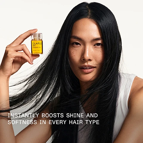 Image 1 - A person with long, straight black hair is holding a small bottle of OLAPLEX No. 7 bonding oil, with the text below reading INSTANTLY BOOSTS SHINE AND SOFTNESS IN EVERY HAIR TYPE.
Image 2 - A close-up image of a glass bottle filled with golden hair oil tipped slightly, with a drop of oil falling from the spout, featuring the text 125% MORE SHINE* *Compared to bleached hair without application of OLAPLEX N°7 Bonding Oil™.
Image 3 - Image shows two OLAPLEX hair care products, the No. 6 Bond Smoother in a white bottle on the left and the No. 7 Bonding Oil in a clear bottle on the right, with text indicating to pair them for smooth styling and noting their benefits.
Image 4 - A comparison of hair texture and color with the left side labeled BEFORE showing frizzy, dull hair and the right side labeled AFTER displaying smooth, shiny curls; additional text at the bottom notes UNRETOUCHED IMAGES and describes the hair care process used.
Image 5 - Image showing a comparison of hair texture before and after using hair care products, with the left side displaying frizzy, unkempt hair labeled BEFORE and the right side showing smooth, shiny hair labeled AFTER. Visible text includes UNTOUCHED IMAGES* and *Results may vary. Results achieved by cleansing with N°4 Bond Maintenance® Shampoo, conditioning with N°5 Bond Maintenance® Conditioner, then applying OLAPLEX N°7 Bonding Oil™ to damp hair before styling and again to dry hair.
Image 6 - A comparison image showing two sections of hair labeled BEFORE on the left side with frizzy hair texture, and AFTER on the right side with well-defined curls; visible text includes UNRETOUCHED IMAGES and a note about results achieved with specific hair products.