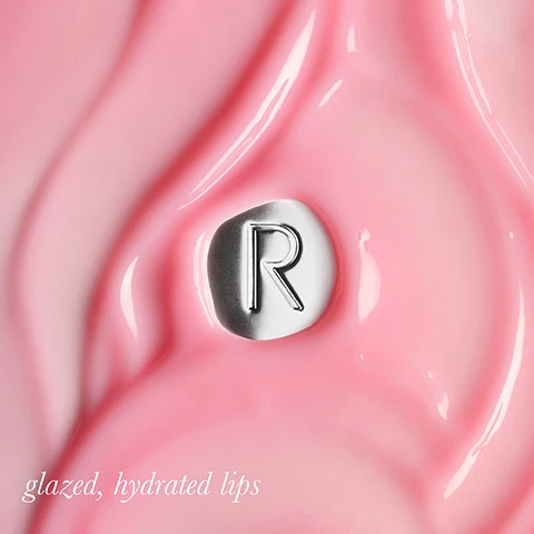 Image 1 - A shiny pink background with a silver circular emblem featuring the letter R, accompanied by the text glazed, hydrated lips.
Image 2 - Image features a glossy red surface with a silver circular element marked with the letter R, accompanied by the text glazed, hydrated lips.
Image 3 - A close-up image of glossy, pink lips with a silver circular emblem featuring the letter R on the surface, accompanied by the text glazed, hydrated lips.
Image 4 - A woman with long, dark hair is holding a tube of Rodial Vegan Collagen skincare product near her face, showcasing her glowing skin; the image includes text that reads THE BENEFITS: Vegan Collagen infused formula to improve the look of lines Macadamia, hibiscus, jojoba, and sweet almond oils lock in moisture Antioxidant Cherry Oil.