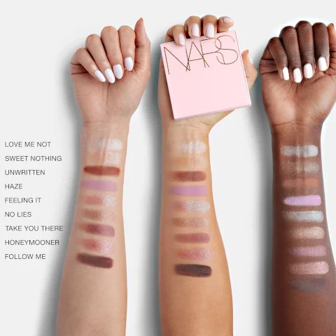 Image shows three arms with different skin tones swatching a range of eyeshadow shades, and a pink NARS palette is held in one hand; visible text includes the names of the shades: LOVE ME NOT, SWEET NOTHING, UNWRITTEN, HAZE, FEELING IT, NO LIES, TAKE YOU THERE, HONEYMOOONER, FOLLOW ME.