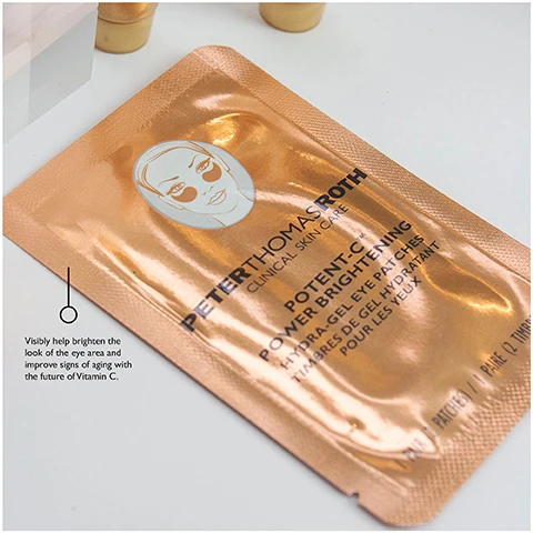 Image 1 - Image of a copper-colored skincare mask packet featuring a womans illustration and text stating PETER THOMAS ROTH CLINICAL SKINCARE POTENT-C POWER BRIGHTENING EYE GEL PATCHES with a note that says visibly help brighten the look of the eye area and improve signs of aging with the future of Vitamin C.
Image 2 - Two tubes of gold-colored skincare treatment are displayed on a clear acrylic stand, with the label reading Infused with 24K Gold and Colloidal Gold, this ultimate luxurious anti-aging treatment.
Image 3 - A tube of Peter Thomas Roth Potent-C Brightening Vitamin C moisturizer, standing on a clear acrylic block, with accompanying text describing its benefits and ingredients.