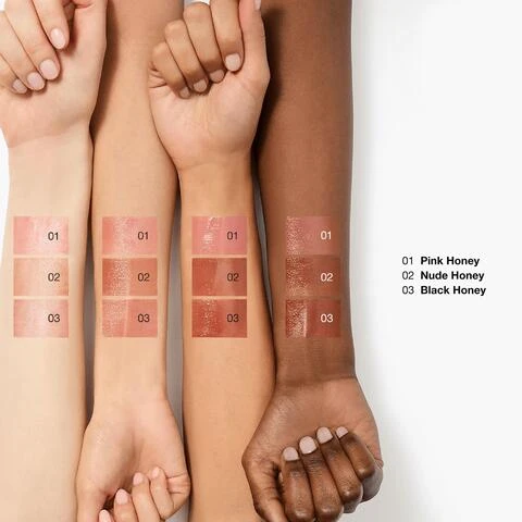 Image 1 - Four forearms with diverse skin tones display swatches of three lip products numbered 01, 02, and 03, with corresponding text on the right listing 01 Pink Honey, 02 Nude Honey, 03 Black Honey. Image 2 - Three lipsticks in silver tubes are shown vertically with honey dripping on them: a dark black cherry shade labeled Black Honey, a pink shade labeled Pink Honey, and a nude brown shade labeled Nude Honey. Image 4 - A close-up portrait of three smiling women with the text Models wear Nude Honey. Image 2 - Close-up of cosmetic swatches in shades of pink and red with a liquid drop icon and the text add sheer color.