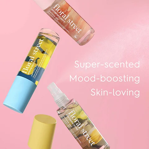 Three Floral Street perfume mist bottles are displayed on a pink background, with one spraying mist and a yellow cap resting nearby, and text reading floral street wonderland peony perfume mist, floral street arizona bloom perfume mist, floral street wild vanilla orchid perfume mist, Super-scented Mood-boosting Skin-loving.